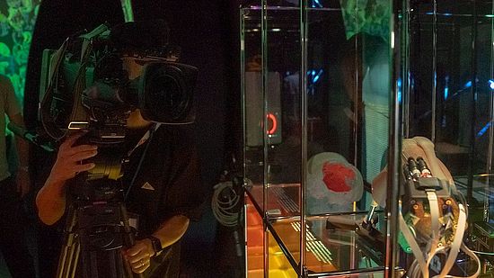 Man with a camera pointed at the MIRACLE display